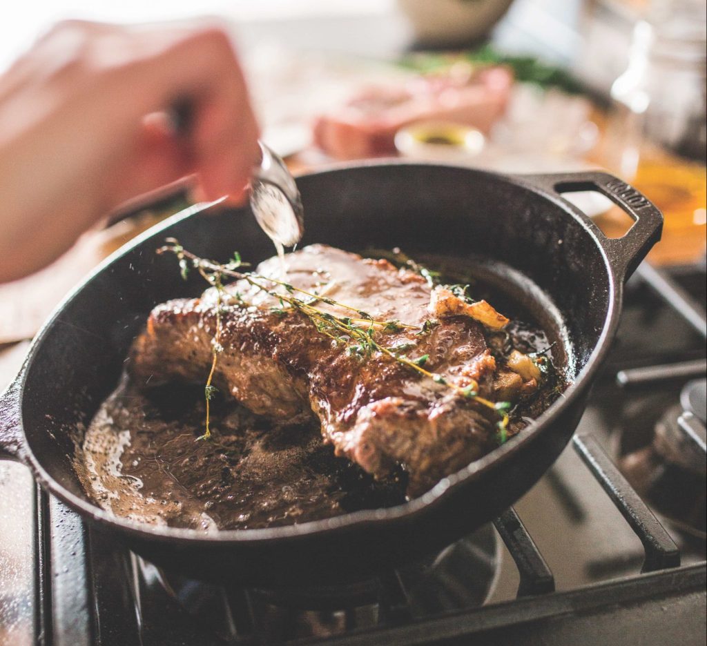 steak cooking in a cast-iron skillet