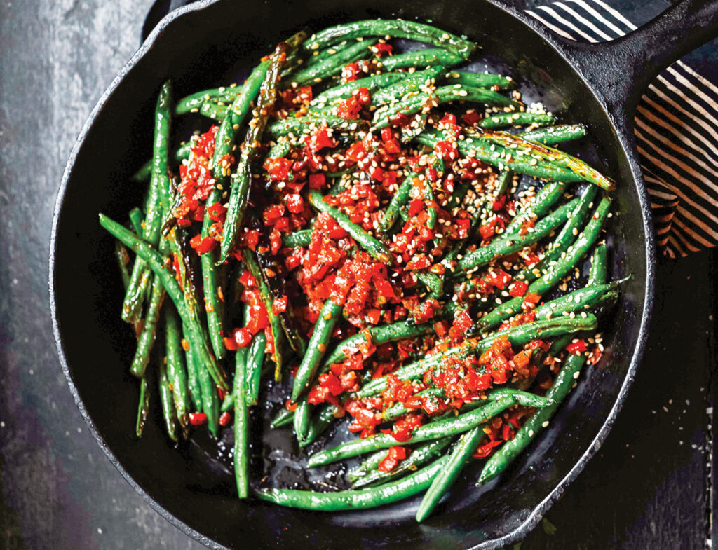 Green beans in red pepper sauce, blistering in cast iron skillet