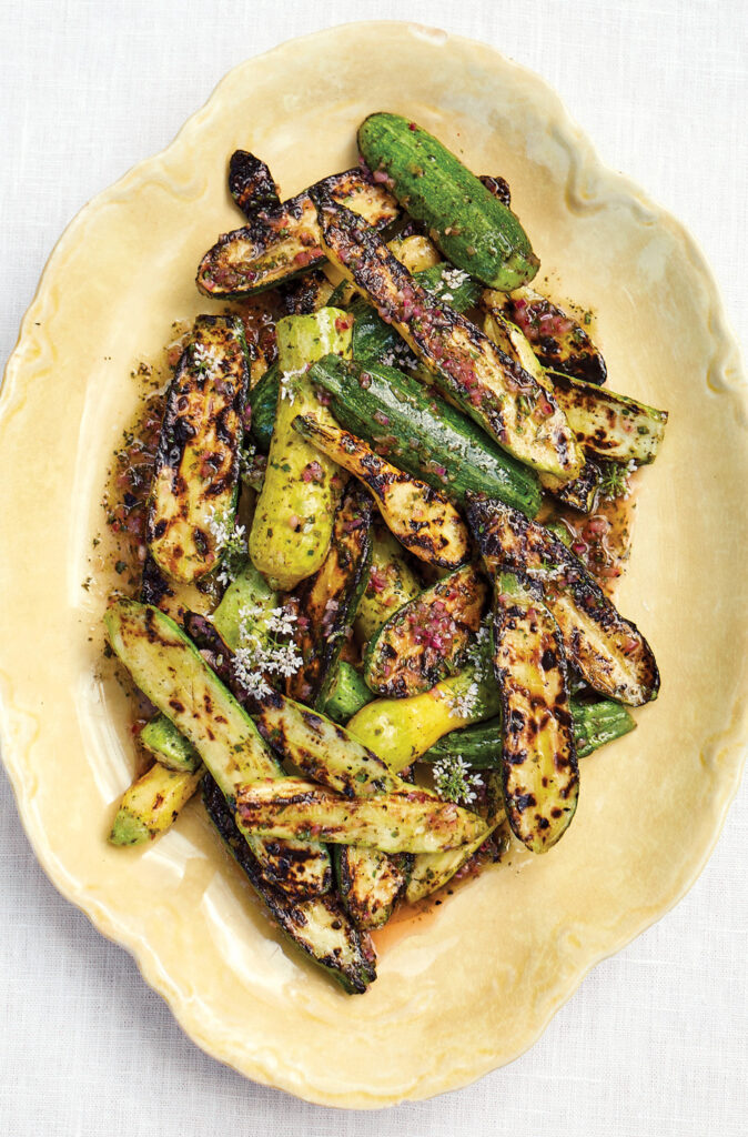 Grilled summer squash and zucchini in yellow oval serving dish