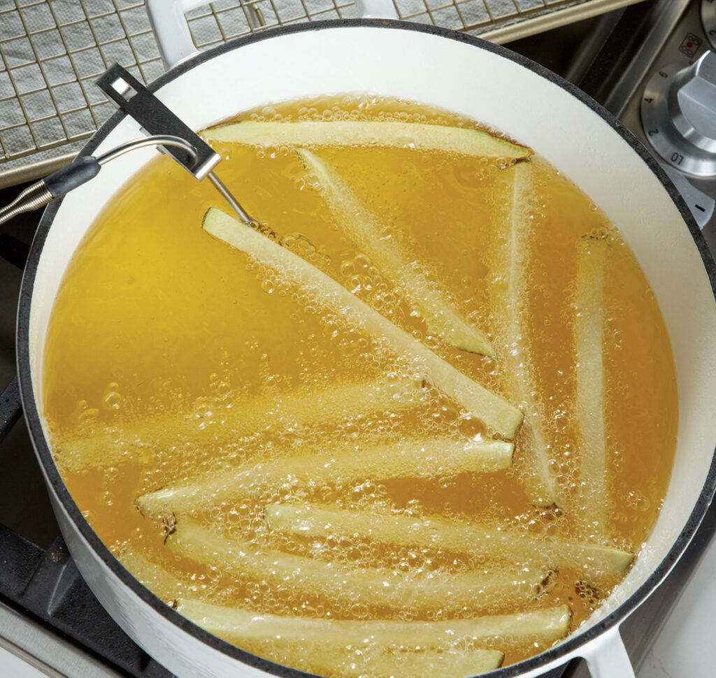 Step 4. First cook: Heat the oil over medium heat to 300°. Working in batches, fry the potatoes until lightly browned, about 5 minutes.