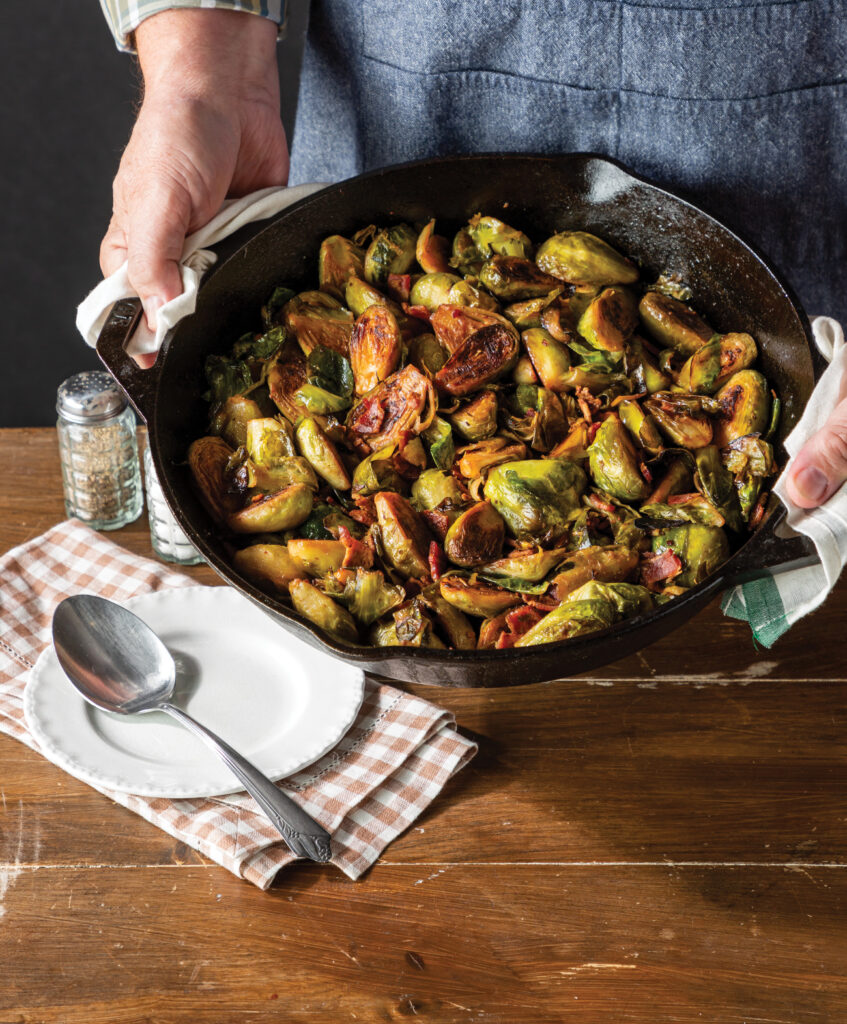 BACON BALSAMIC GLAZED BRUSSELS SPROUTS being served up from a skillet