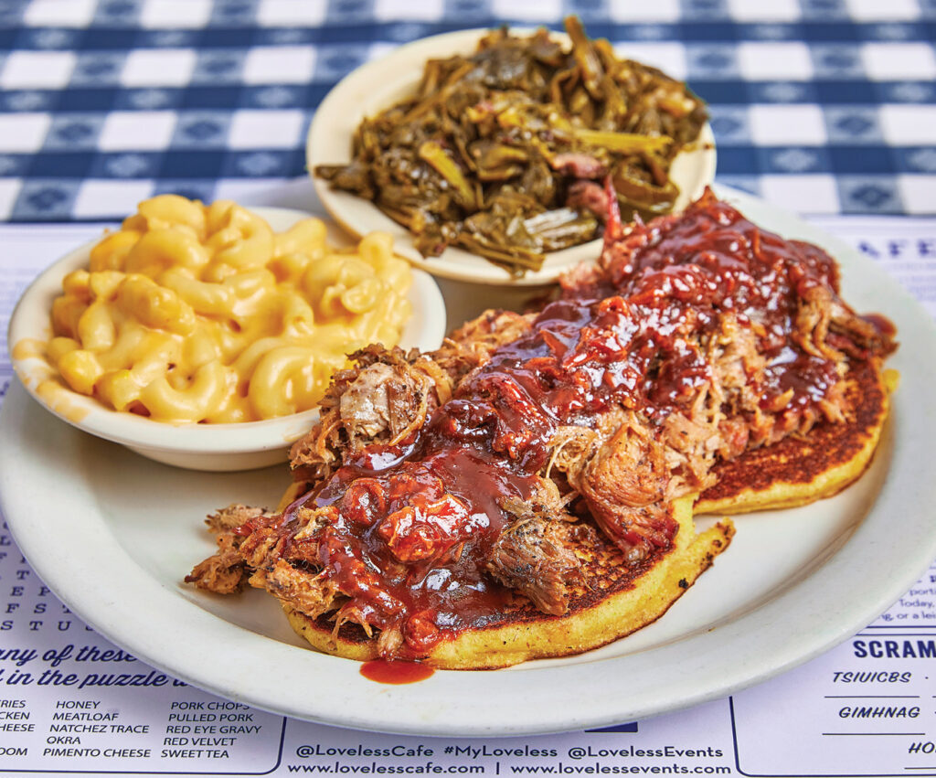 Pulled pork plate on hot cakes with macaroni and cheese and green bean sides. 