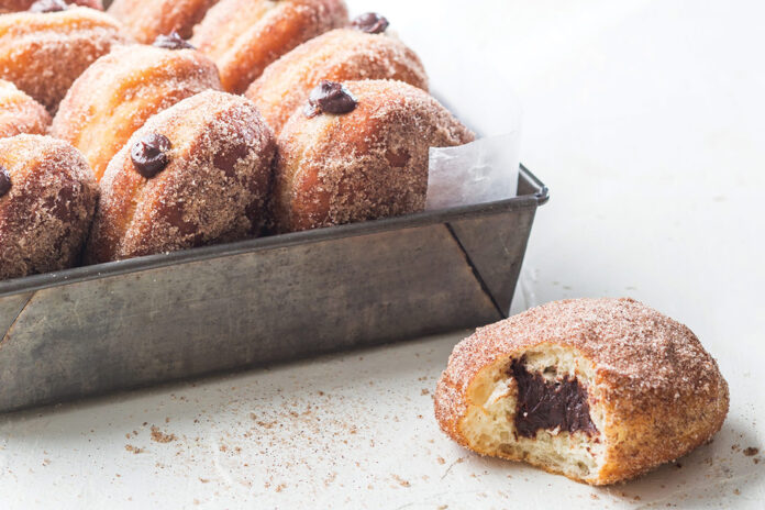 Bring the pastry shop to your home with these chocolate-filled Cinnamon Hot Chocolate Doughnuts.